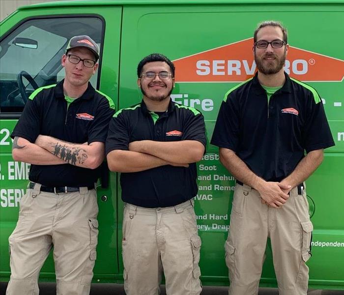 Three guys in black shirts, green van