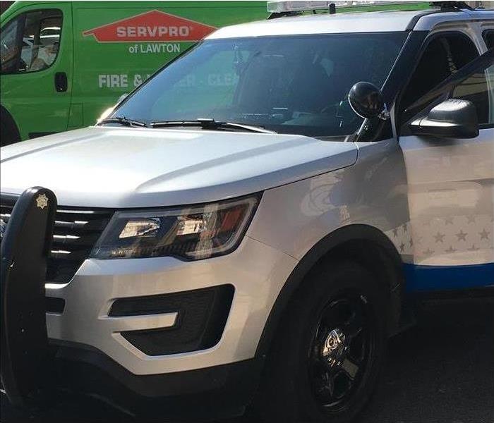 silver police car, green truck in background