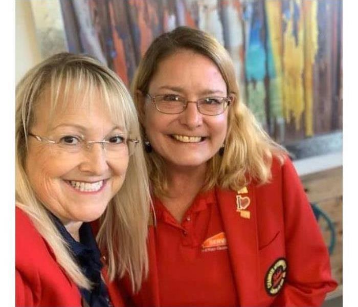 two blonde women in red coats