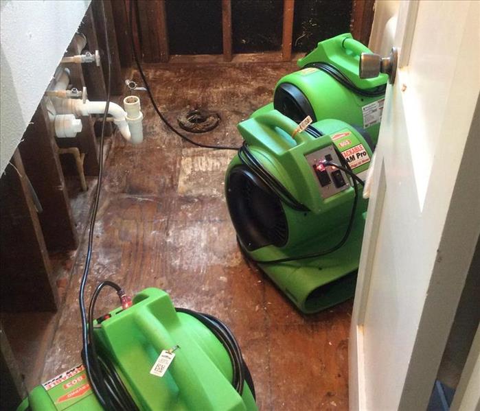 bare bathroom floor, bare studs, green equipment